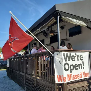 a group of people standing on the porch of a restaurant