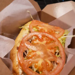 a sandwich with tomatoes and lettuce