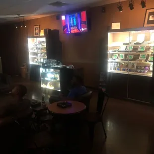 a man sitting at a table in front of a vending machine