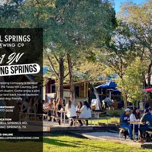 a group of people sitting at tables under umbrellas