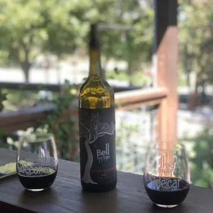 two glasses of wine and a bottle of wine