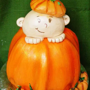 a baby in a pumpkin shaped cake