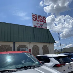 a car parked in front of a subs store