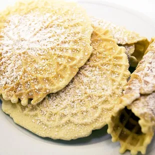 Traditional Italian Pizzelle with a deep anise flavor and sprinkled with powdered sugar.