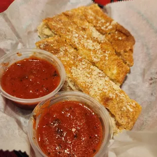 two small bowls of sauce and a piece of bread