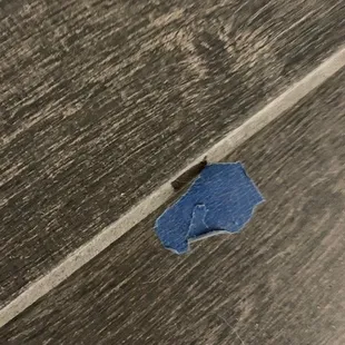a piece of blue tape on a wood floor