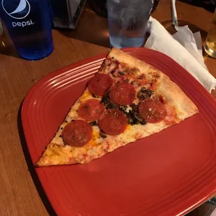 Pizza slice with pepperoni and mushrooms.