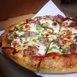 a pizza with sausage, mushrooms, peppers, and cheese