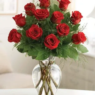 A timeless classic, the Red Rose bouquet! One dozen beautiful red roses arranged in a glass vase with greens and accent fillers, say I Love