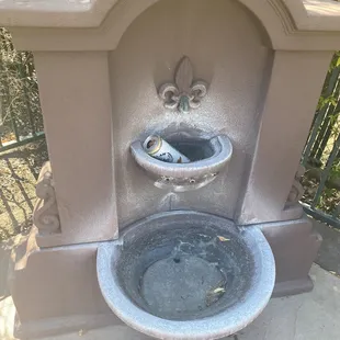 Broken pool fountain with beer can.