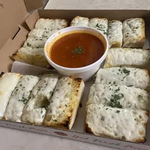 Two orders of cheesy garlic bread with marinara sauce
