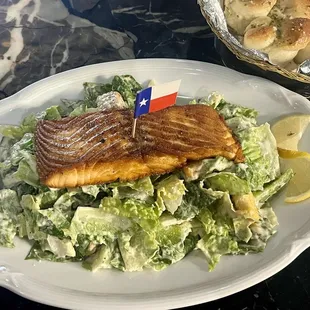Cesar salad with salmon and fresh garlic bread.