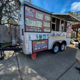 Little food truck in a gas station parking lot