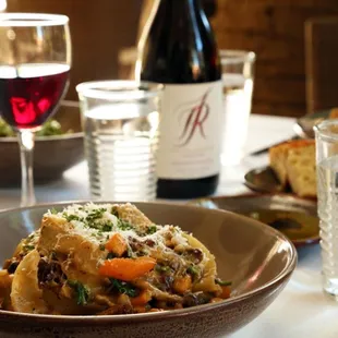 a bowl of pasta and a glass of wine