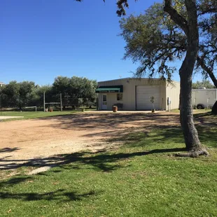 a dirt lot with a building in the background