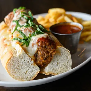 a meatball sandwich and french fries