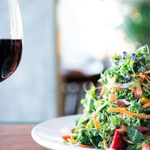 a plate of salad and a glass of wine