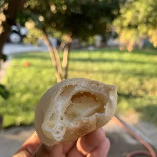 a hand holding a half eaten pastry