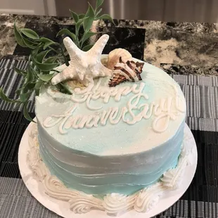 a blue and white cake decorated with seashells