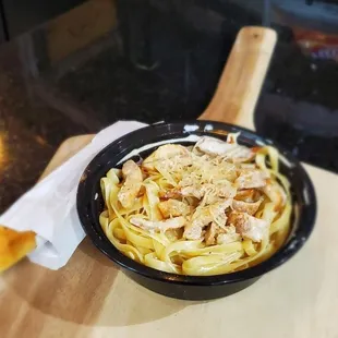 a bowl of pasta on a cutting board