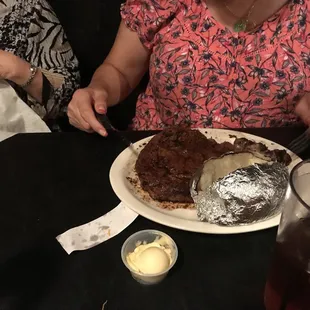 a woman sitting at a table with a plate of food