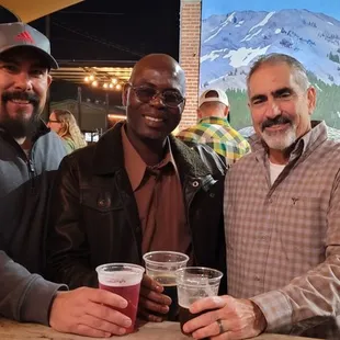 three men holding beer glasses