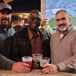 three men holding beer glasses