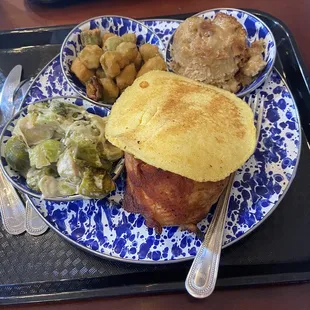 A full plate with bbq chicken fried okra and Brussels sprouts bread pudding and corn bread.