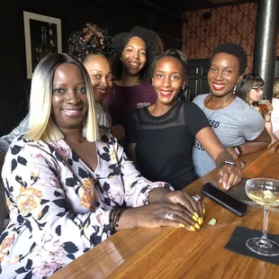 a group of women sitting at a bar