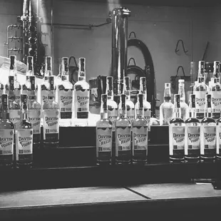 a black and white photo of bottles of spirits