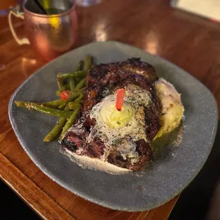 a plate of steak with mashed potatoes and asparagus