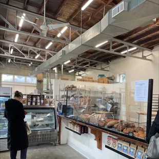 a woman standing in front of a bakery counter
