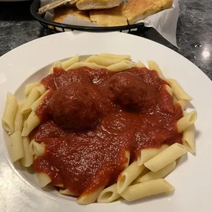 Pasta dinner with meatballs comes with a basket of garlic bread