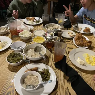 a family sitting at a table with plates of food