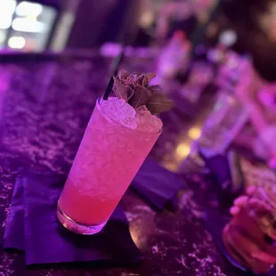a pink cocktail with a garnish garnish