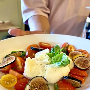 (Special). Burratta cheese with gourmet medley cherry tomatoes and fig with peach vinaigrette dressing.