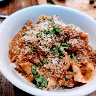 a bowl of pasta with meat and parsley