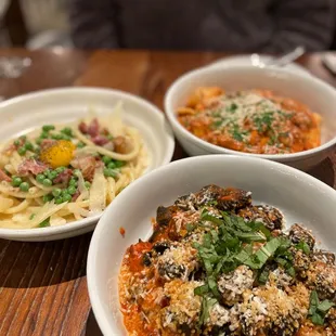 three bowls of pasta on a table