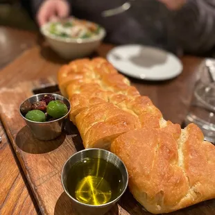 a loaf of bread with olives and olive oil