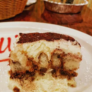 Tiramisu -- Three layers of lady fingers soaked in coffee and liqueur, filled with zabaglione cream, topped with grated Belgium Chocolate