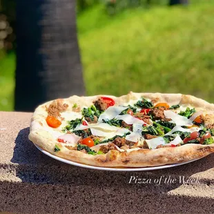 Farmers market baby tomato, rapini, calabrian sausage, midnight moon gouda.