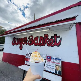 a hand holding a cup of ice cream