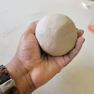 a hand holding a ball of dough