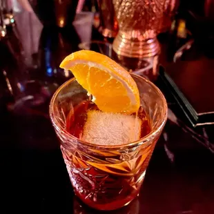 a drink in a glass with an orange slice