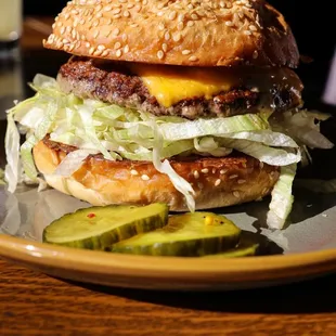 Cheese Burger- Sesame Bun, White Onion, Shredded Lettuce, House Sauce and side of Pickles.
