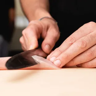 a close up of a person cutting a fish with a knife