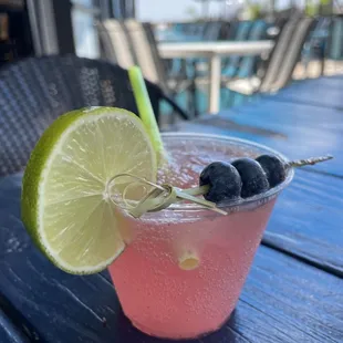 a drink with blueberries and lime