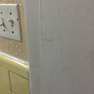 Blood or dirt-stained hand prints on the bathroom door.