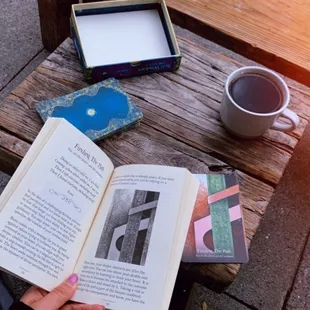 a person reading a book on a bench