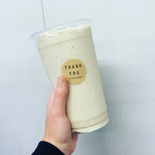 a hand holding a cup of yogurt